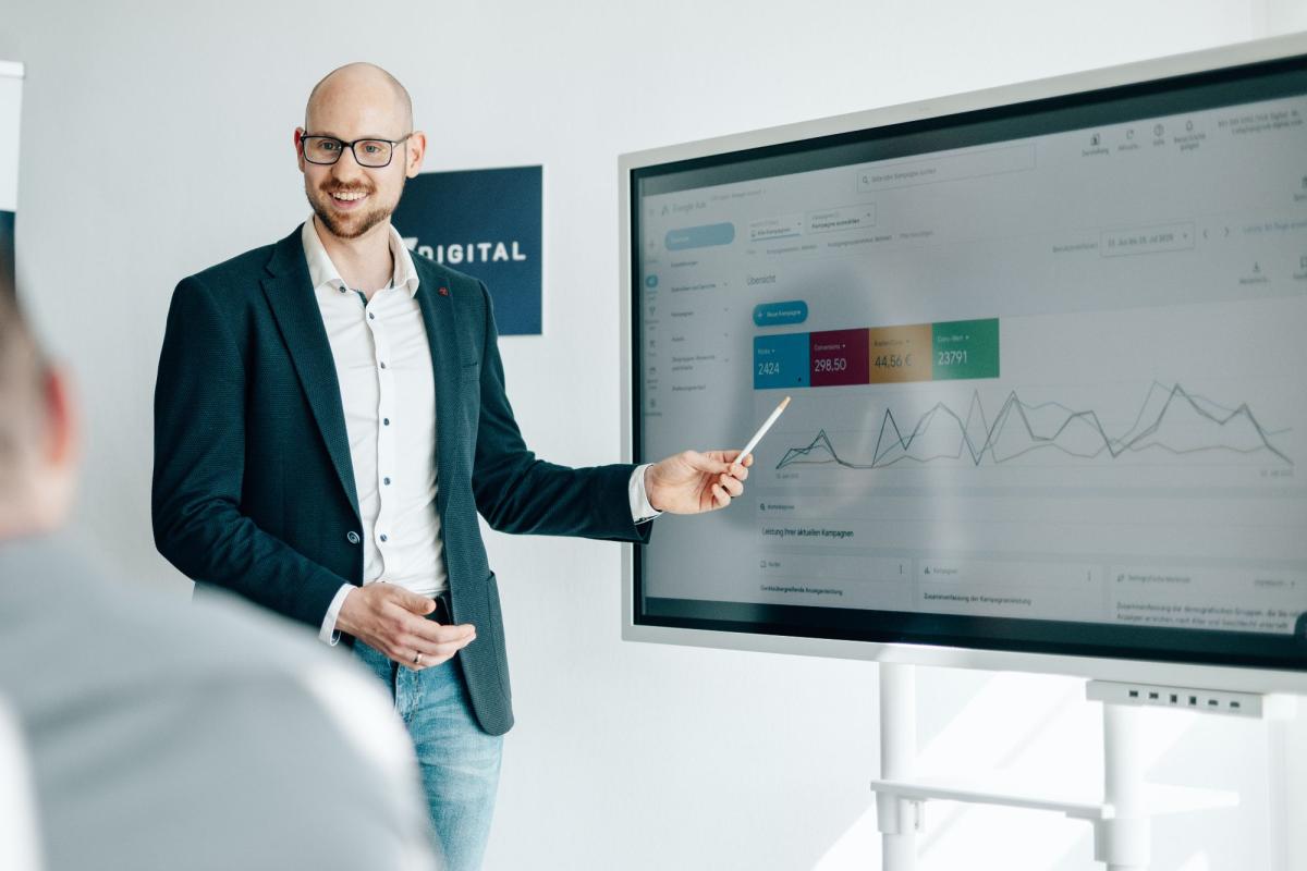 Der Immobiliensachverständige präsentiert Daten über Google Werbung im Meeting.