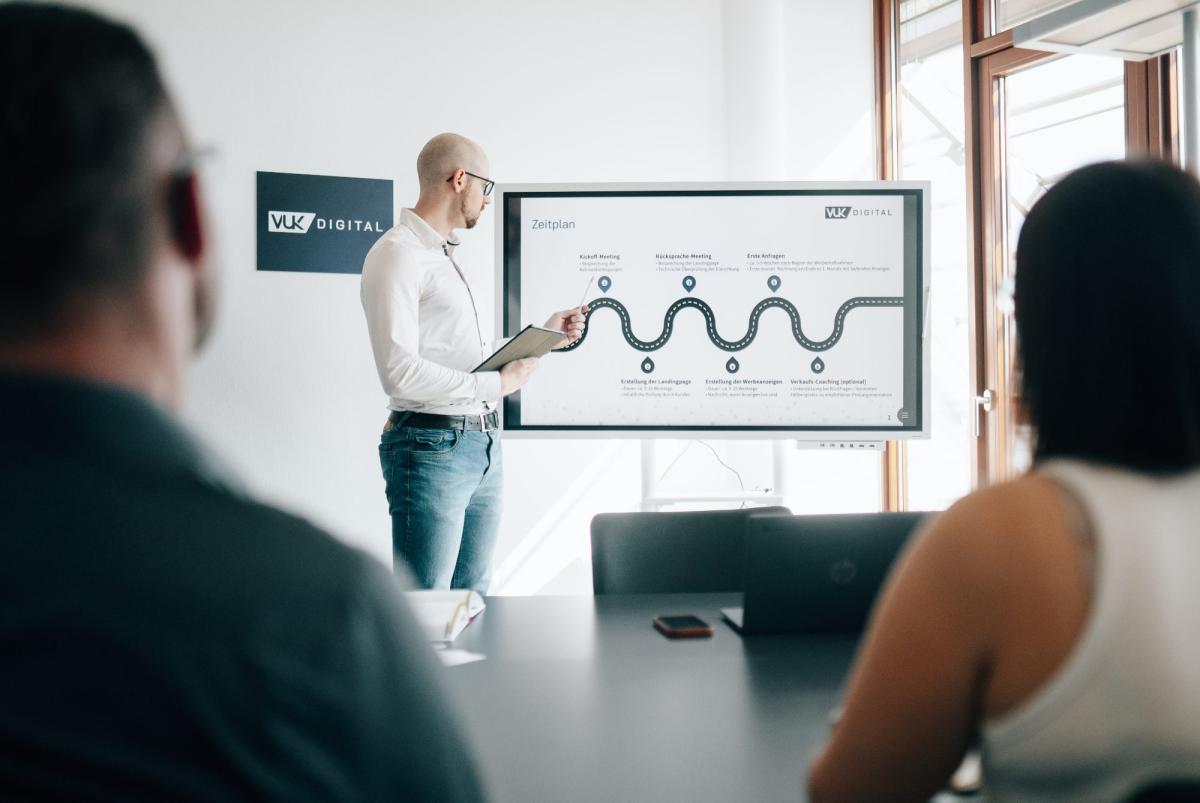 Ein Neustarter-Gutachter präsentiert Marketing-Strategien in einem Meeting.