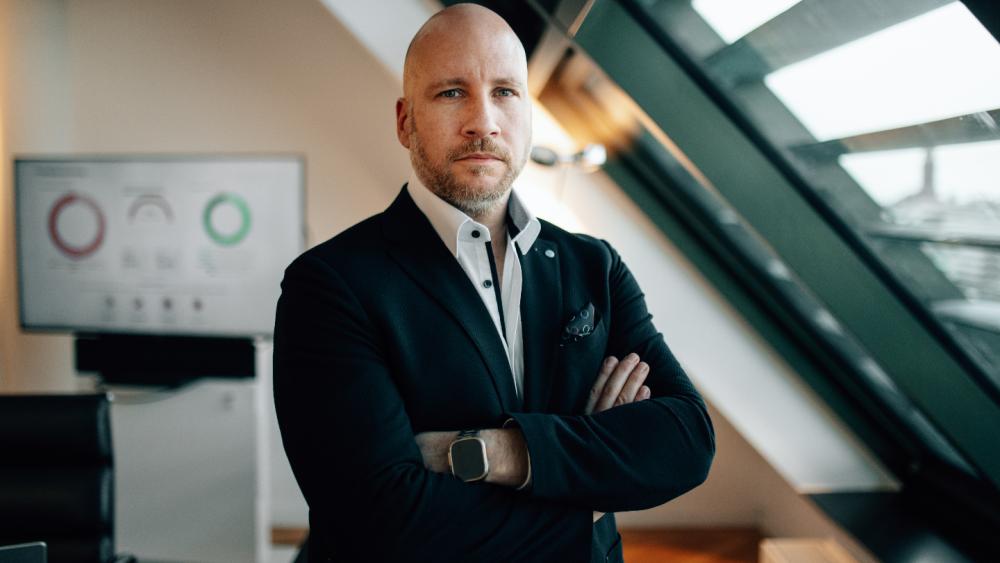 Mann im Anzug mit verschränkten Armen, symbolisiert Investieren über Neobroker.
