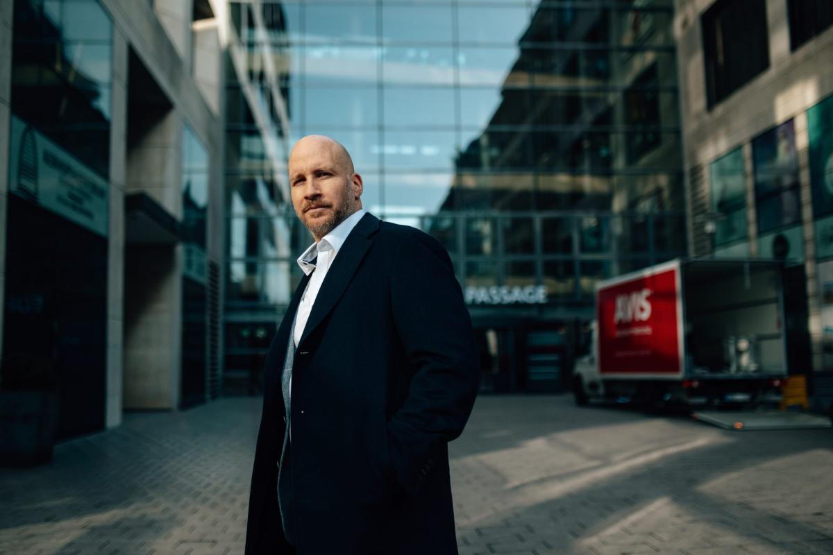 Mann steht in der Stadt und reflektiert über Denkfehler beim Investieren.