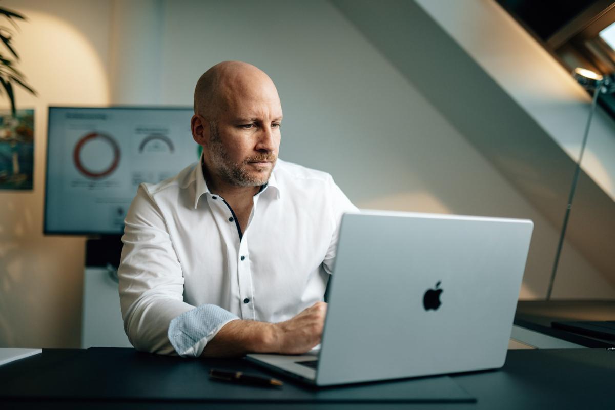 Arbeitnehmer am Laptop, der über Aktienrente und staatliche Förderung informiert wird.