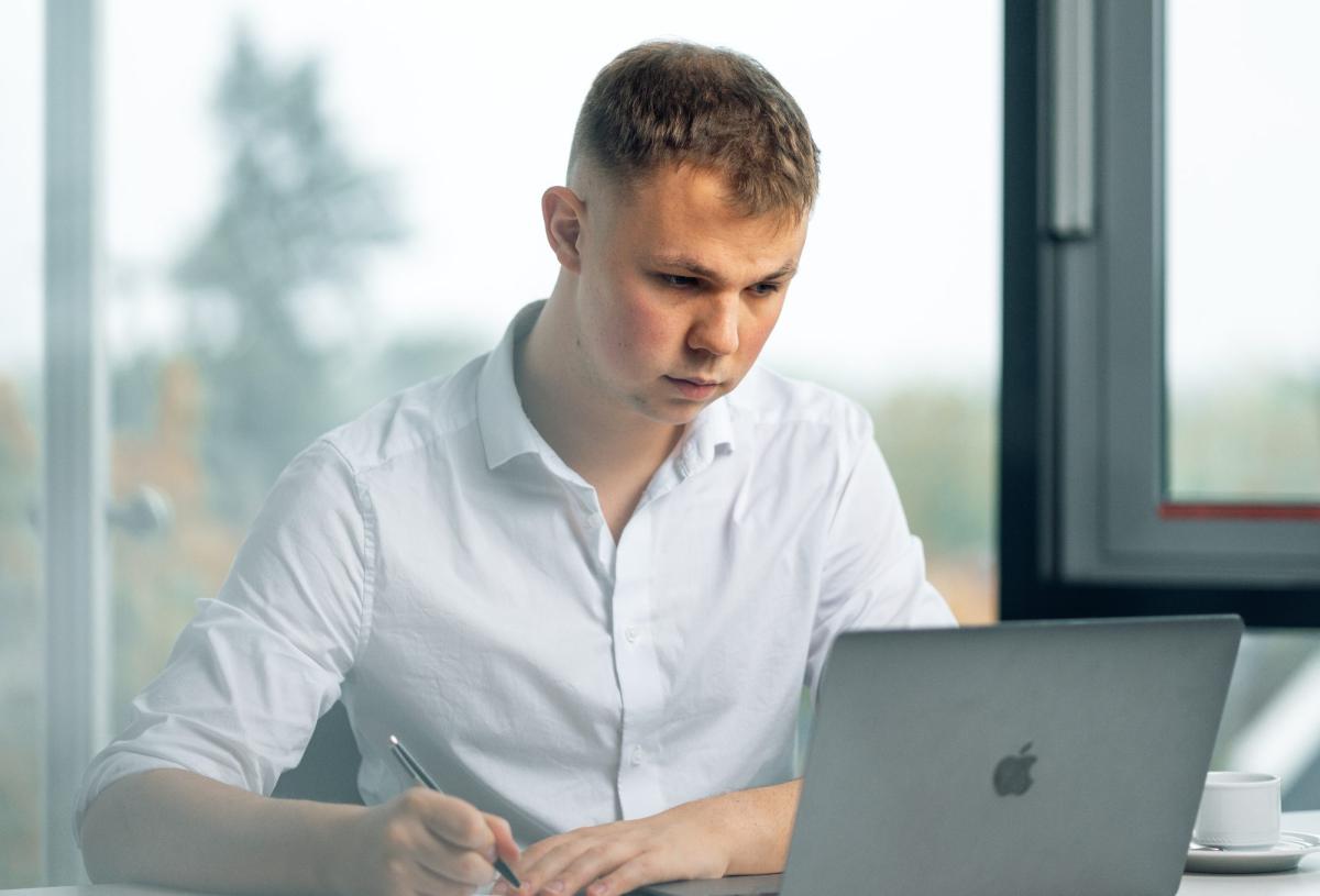 Junger Mann arbeitet am Laptop, um Salesletter Arten zu entwickeln.