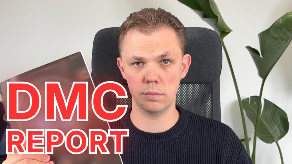 Eine Person hält einen DMC Report in der Hand und schaut in die Kamera.