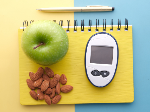 Gesunde Snacks wie ein Apfel und Mandeln für das Abnehmen in den Wechseljahren.