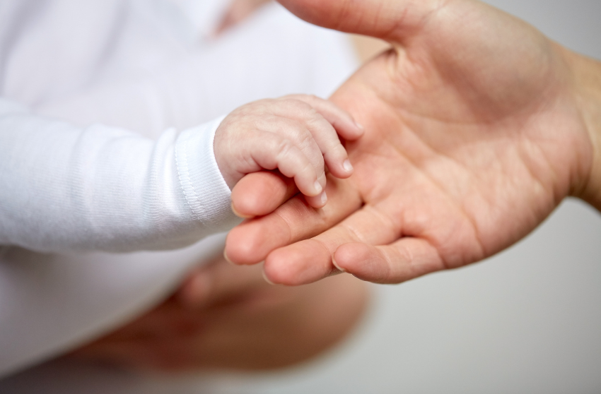 Eine Mutter hält die Hand ihres Babys und symbolisiert die Beziehung zum Essen.