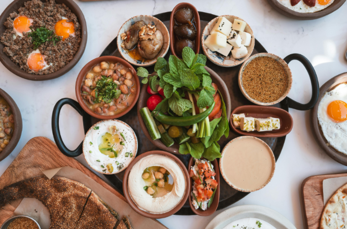 Bunte Platte mit gesunder mediterraner Ernährung, darunter Frisches Gemüse und Dips.