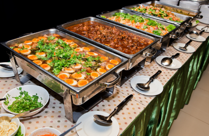Verschiedene Gerichte auf einem Buffet im Luxusurlaub zeigen Buffet-Strategien.