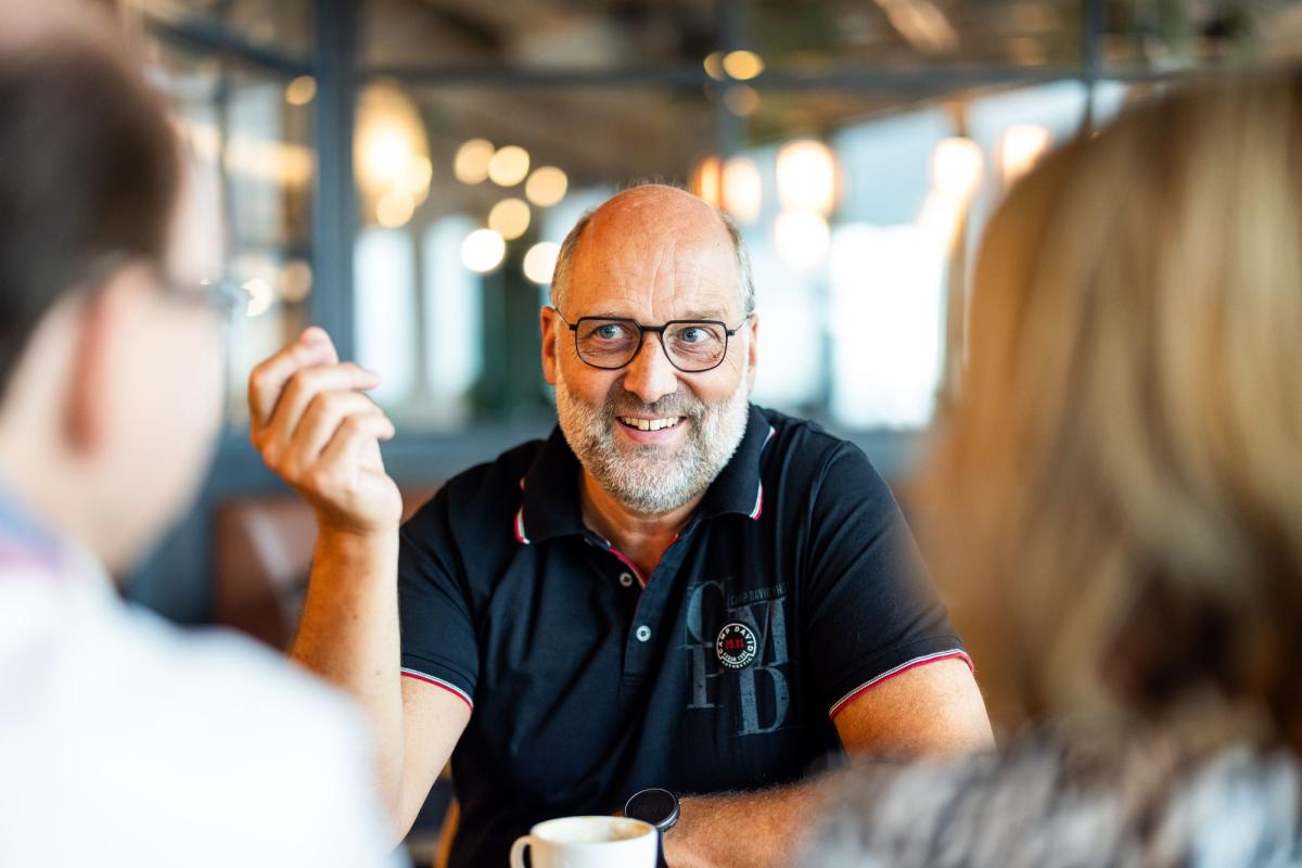 Mitarbeiter-Benefits 2027: Gespräch über Vorteile im Café.
