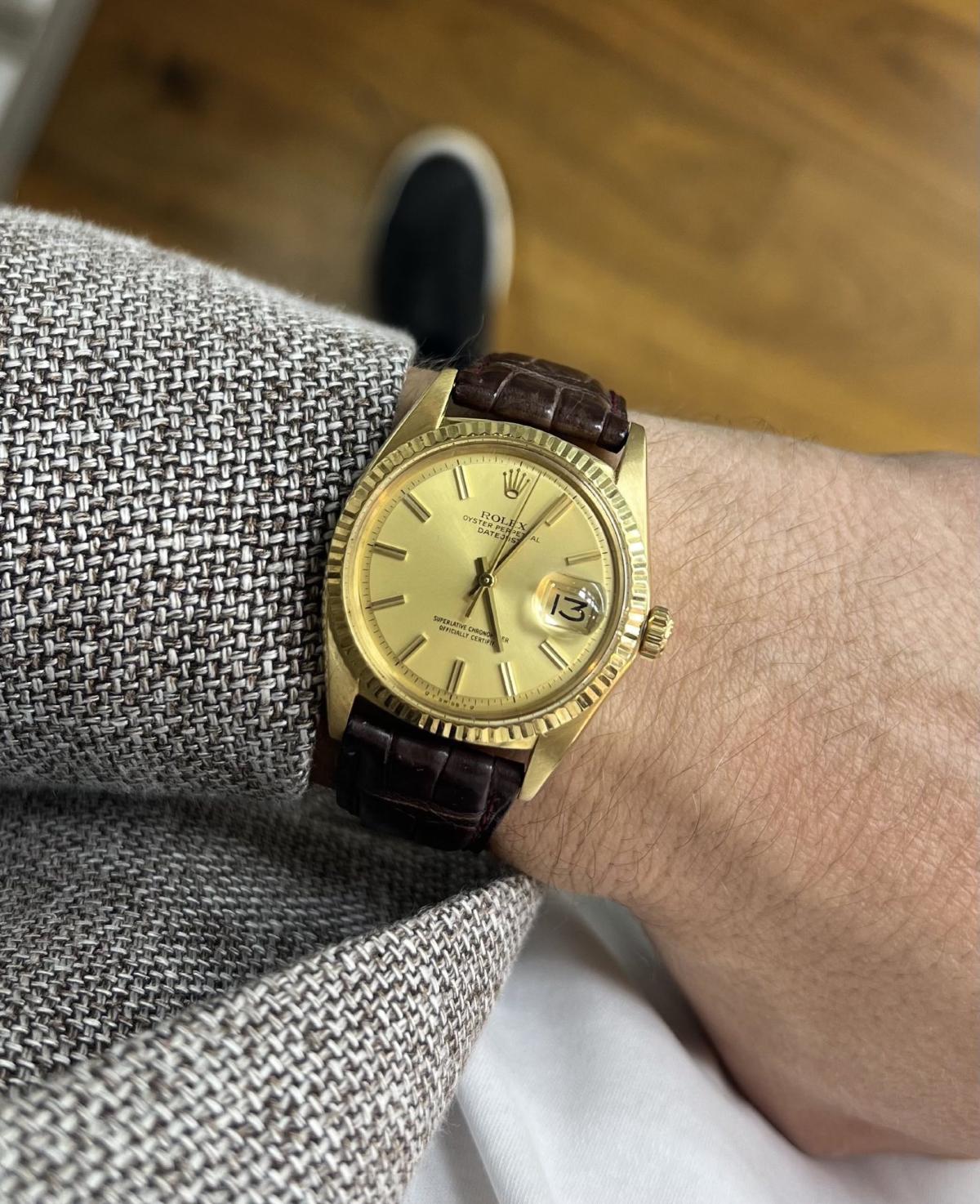 Eine goldene Uhr am Handgelenk, die das Thema Geld manifestieren symbolisiert.