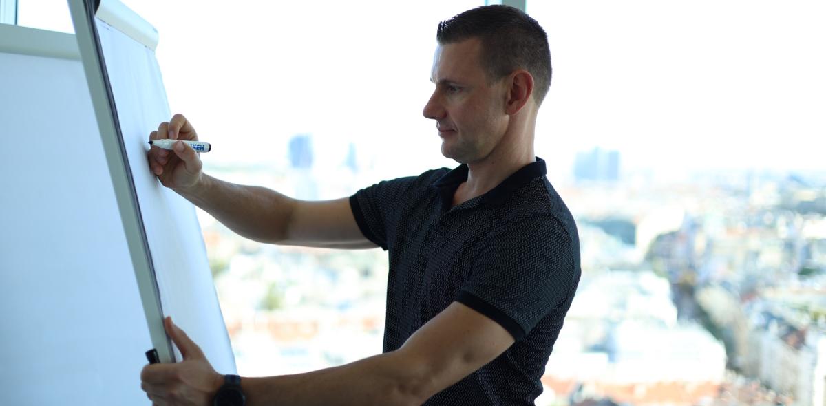 Ein Trainer präsentiert Ideen zur Erfolgsmethode von Matthias Neumann an einem Flipchart.