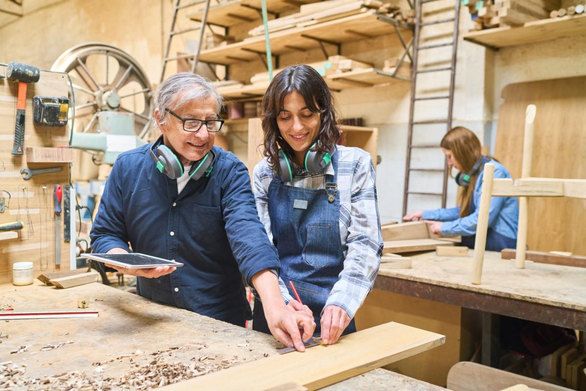 Mitarbeiter zeigen in der Werkstatt, wie man bei Fachkräftemangel als Arbeitgeber sichtbar wird.