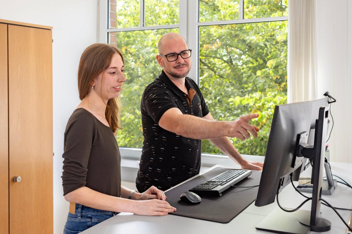 Zwei Personen besprechen die Optimierung des Google Business Profils am Computer.