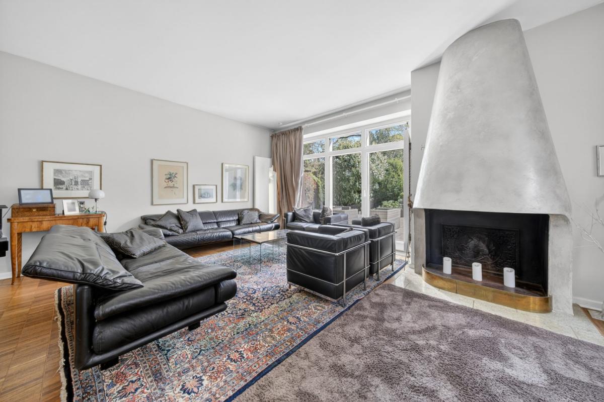 Modernes Wohnzimmer mit gemütlicher Sitzecke und Kamin für Immobilienfotos.