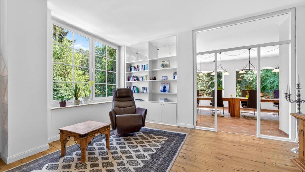Heller Raum mit Bücherregal und gemütlichem Sessel in der Immobilienfotografie.