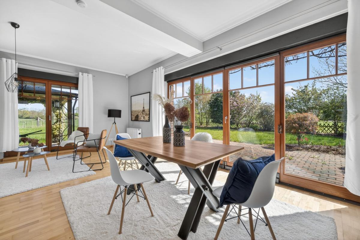 Ein modernes Esszimmer mit Holztisch und Blick auf den Garten, erstaunliche Immobilienfotografie.