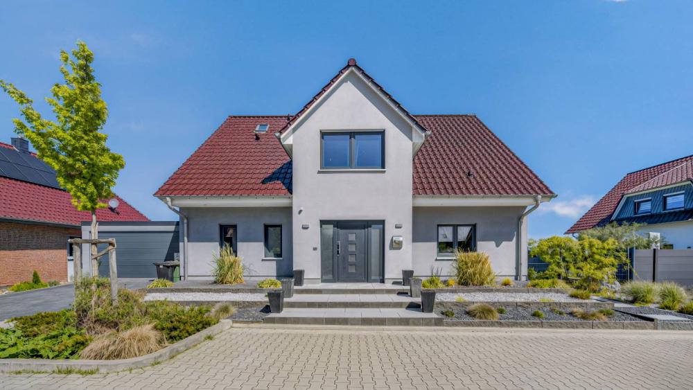 Moderne Villa mit Garten und Pfaden, ideal für Immobilienfotografie.