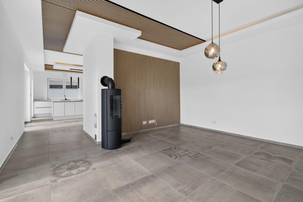 Helles modernes Wohnzimmer mit Kamin und minimalistischer Ausstattung in der Immobilienfotografie.