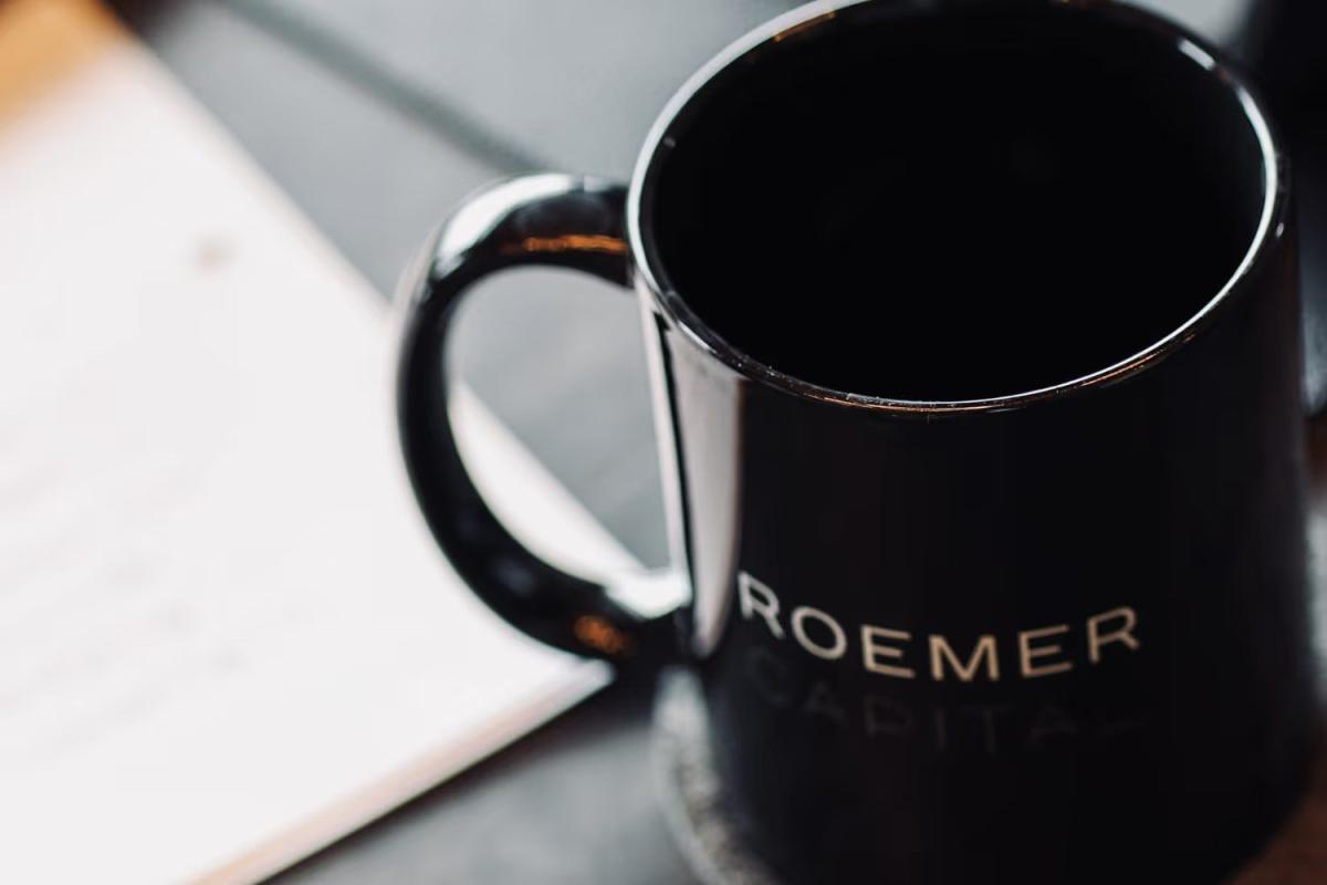 Schwarze Tasse mit der Aufschrift Roemer Capital auf einem Tisch bei einer Fundraising-Checkliste.