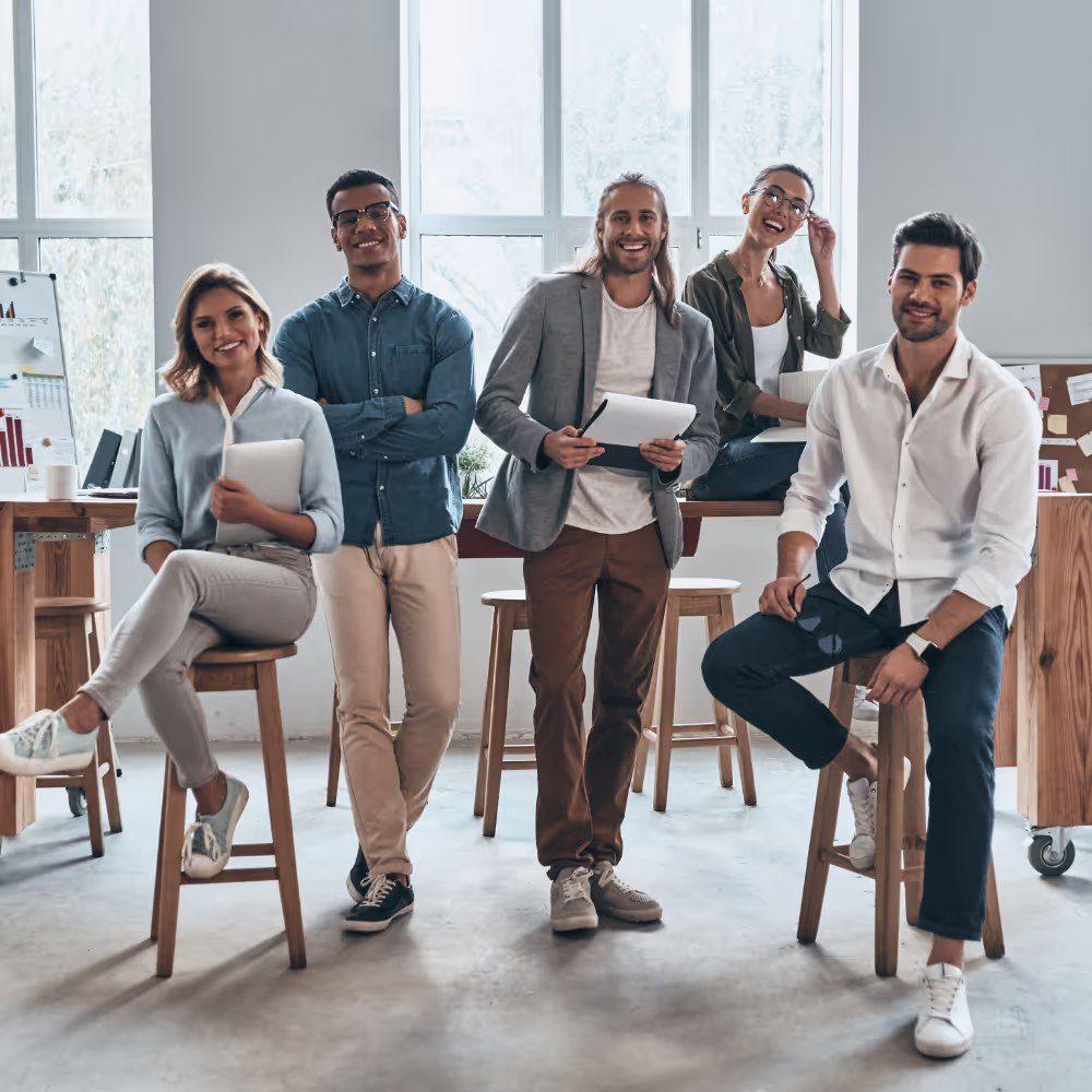 Ein Team von fünf Personen steht im Büro und diskutiert zur Unternehmensfinanzierung im DACH-Raum.