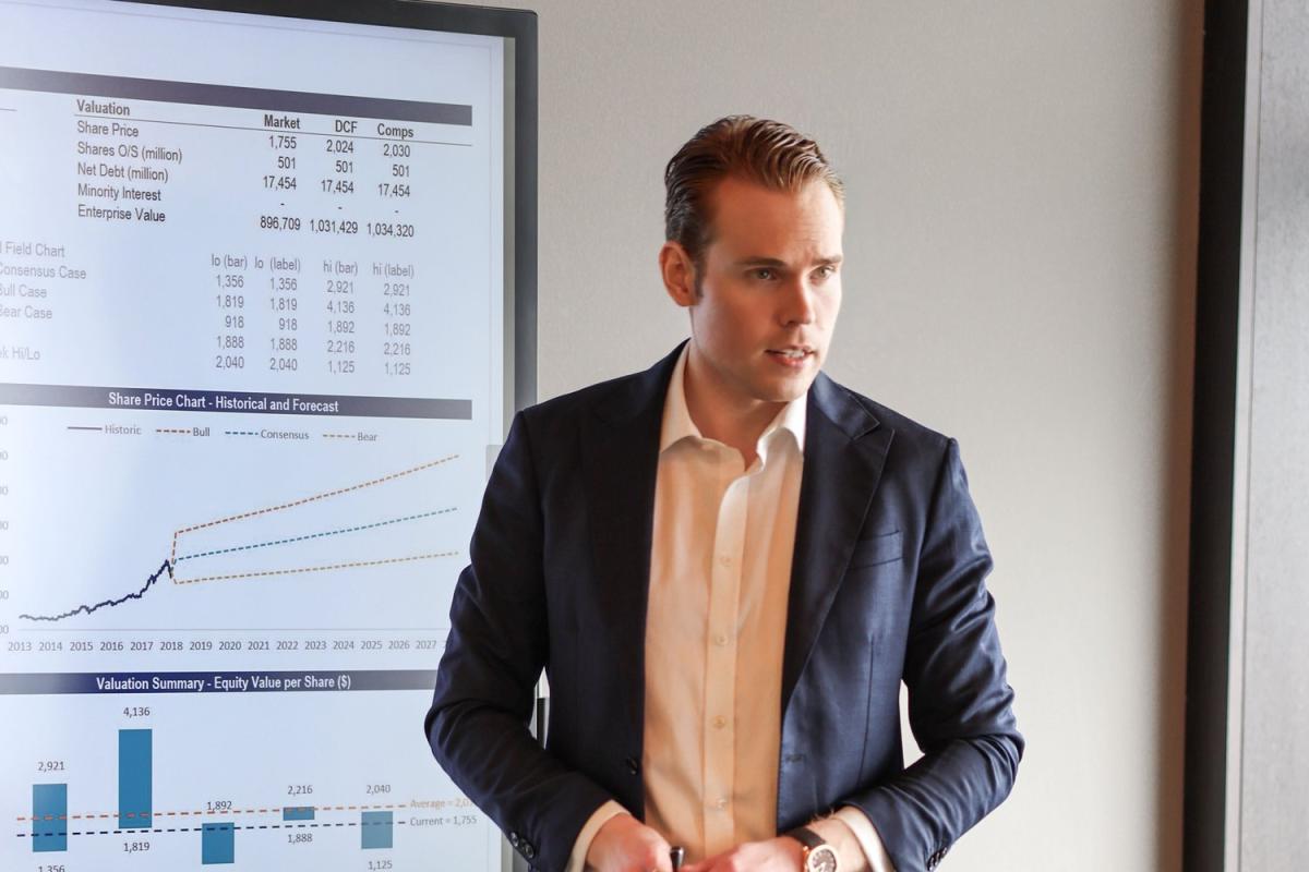 Ein Mann in Anzug steht vor einer Präsentation über Factoring für B2B-Scaleups.