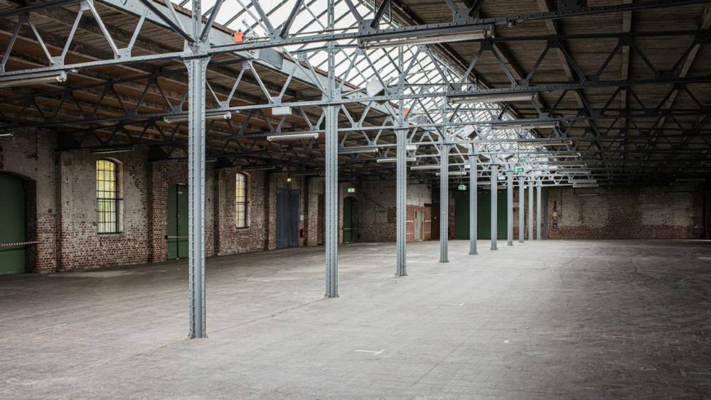 Leere Industriehalle zeigt hohe Decken und klare Strukturen für B2B-Factoring.
