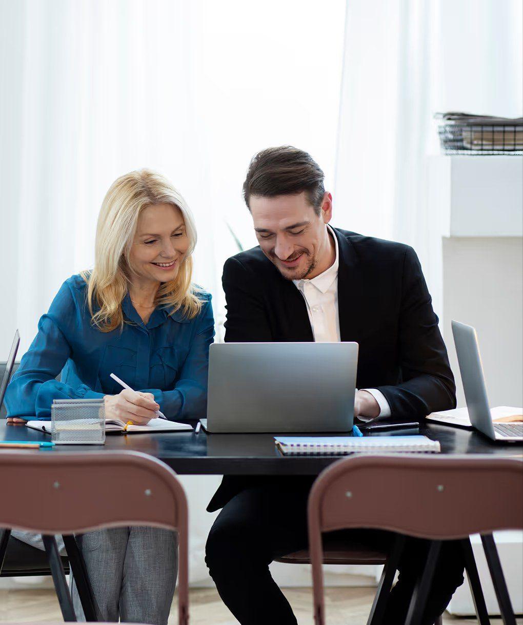 Zwei Gründer arbeiten an einem idealen Investorenprofil am Laptop.
