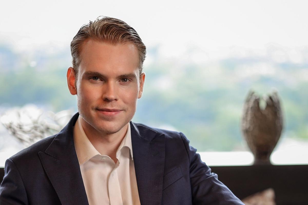 Ein Geschäftsmann posiert am Fenster und spricht über Governance vor dem Unternehmensverkauf.