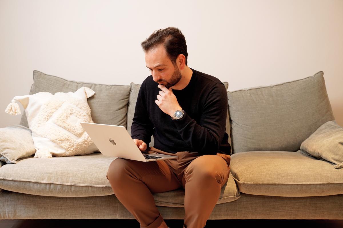 Mann sitzt auf der Couch und denkt über Kündigungen als Chef nach.