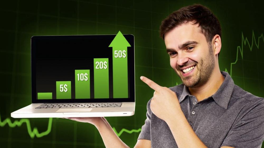 Ein lächelnder Mann zeigt auf einem Laptop steigende Umsatzbalken zu Amazon FBA.