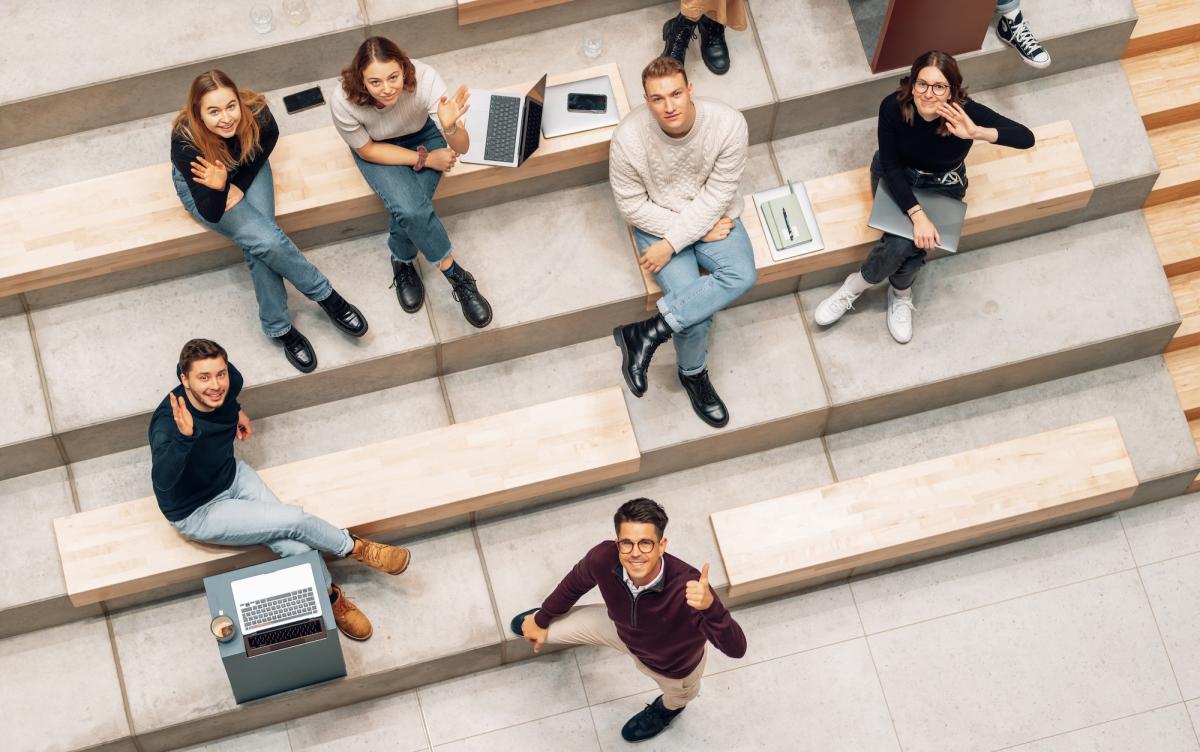 Sechs Studierende sitzen in einer modernen Lernumgebung für ein Studium in den USA.