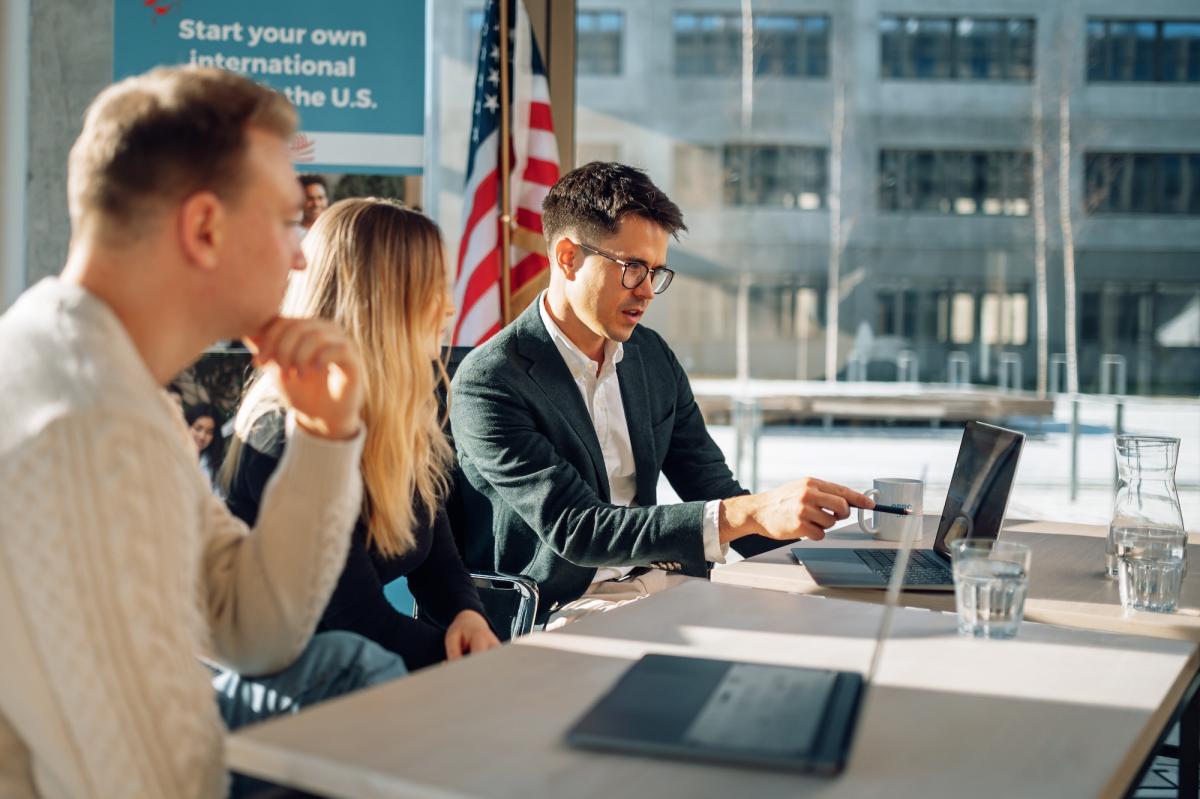 Diskussion über die US-Uni-Bewerbung während einer Präsentation.