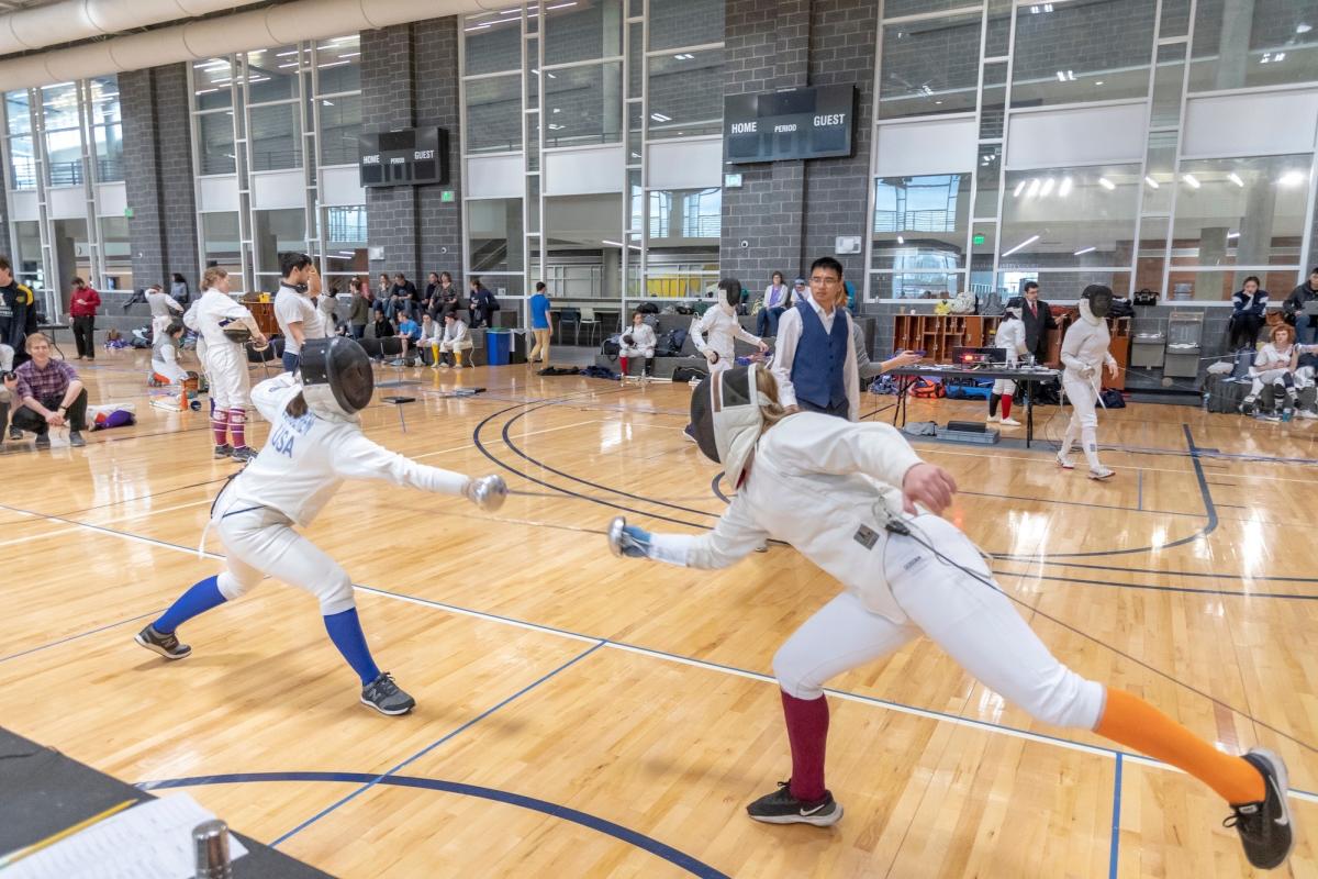 Zwei Fechter im Wettkampf während eines Vereins-Sportturniers, entscheidend für die US-Zulassung.