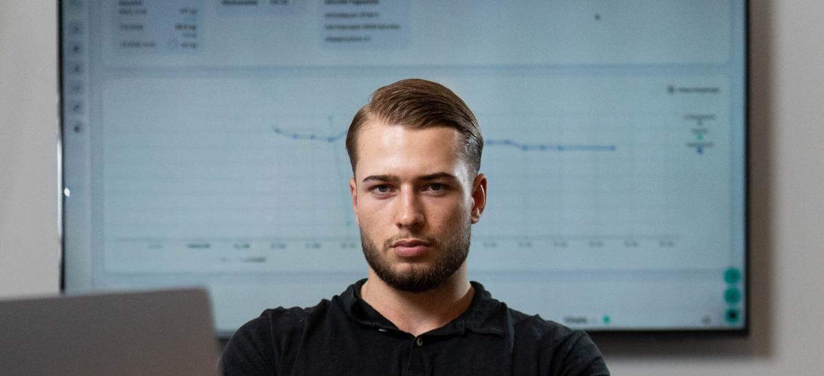 Mann mit ernstem Ausdruck sitzt vor Computer und Grafik zu 4 Kilo abnehmen.