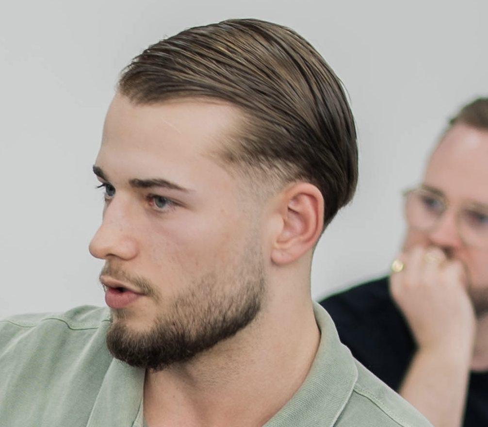 Mann mit moderner Haarfrisur, der über Möglichkeiten zum Bauchfett reduzieren spricht.