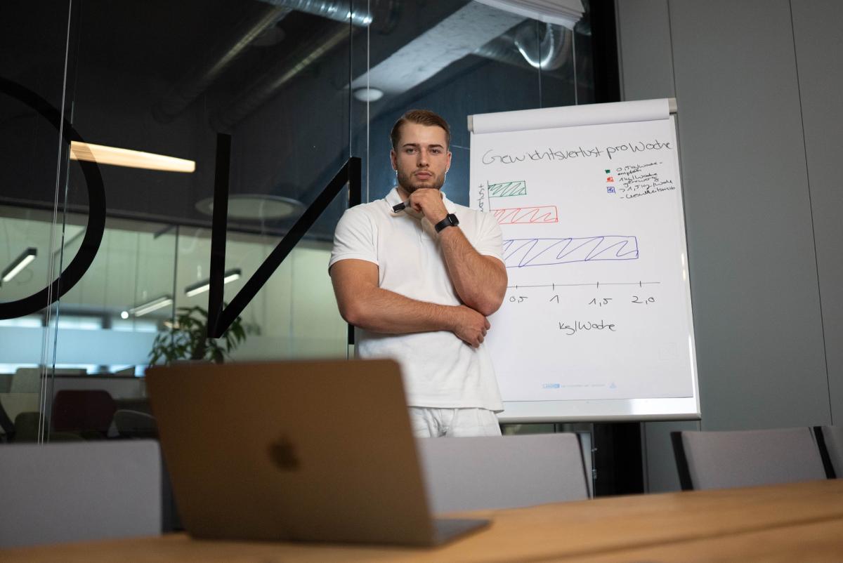Ein Mann steht vor einem Flipchart und präsentiert Möglichkeiten, um Energie zurückzugewinnen.