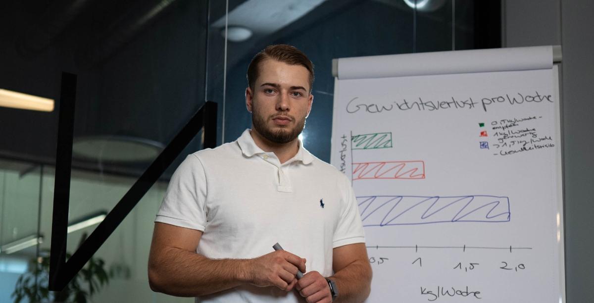 Präsentator spricht über Übergewicht und Respekt vor einer Flipchart.