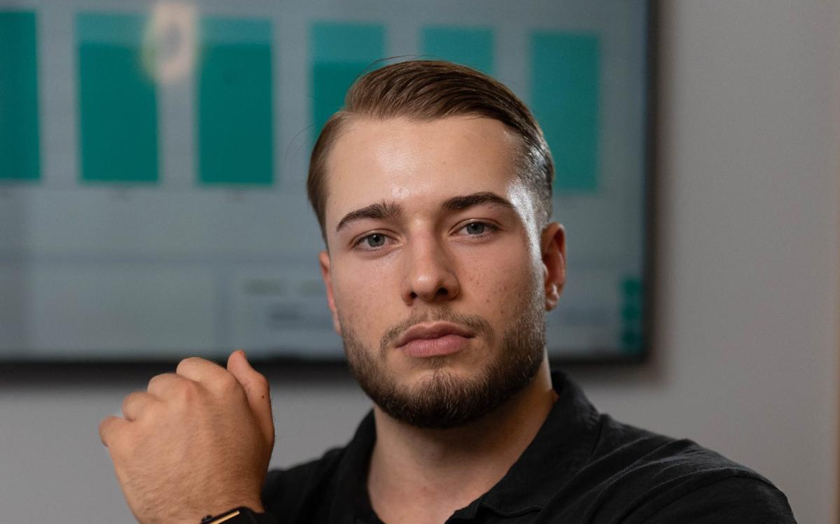 Ein Mann mit ernstem Gesichtsausdruck zeigt auf eine Grafik im Hintergrund, die Lebensmittel zeigt, die die Fettverbrennung sabotieren.