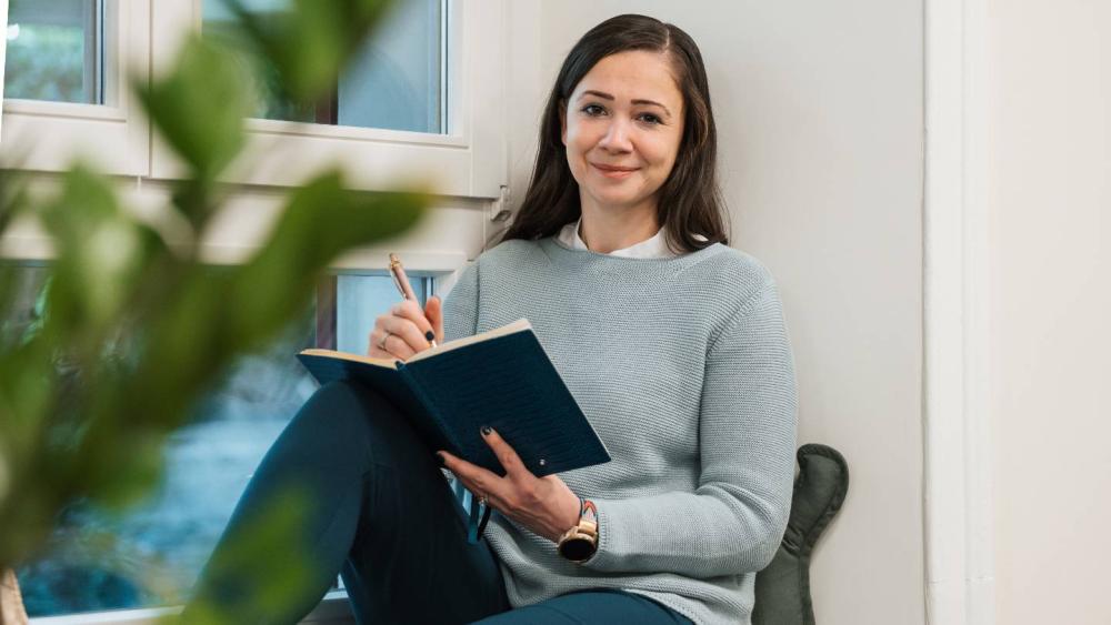Eine Frau notiert Informationen zur Verkaufsfähigkeit von Vermögensverwaltern.