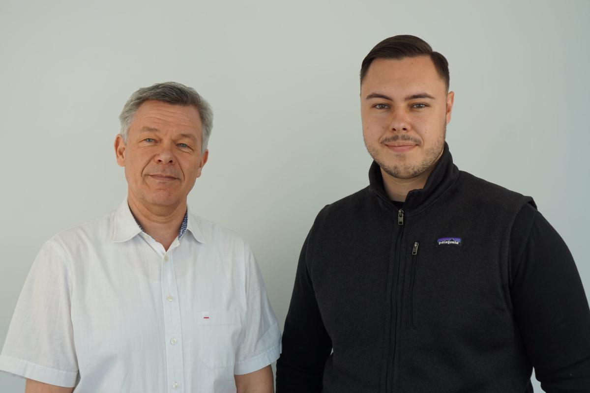 Zwei Männer im Büro, die über Moneymaking Activities diskutieren.
