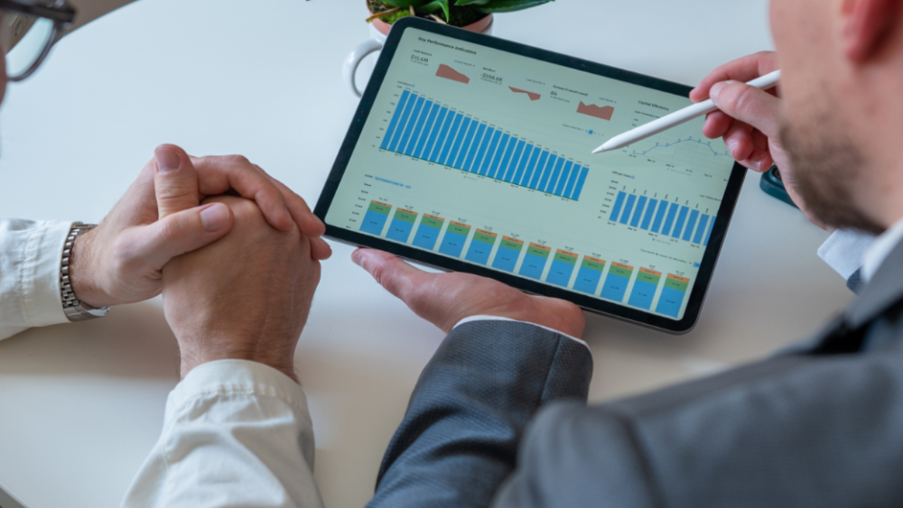 Zwei Personen betrachten ein Dashboard mit Kennzahlen im Mittelstand auf einem Tablet.
