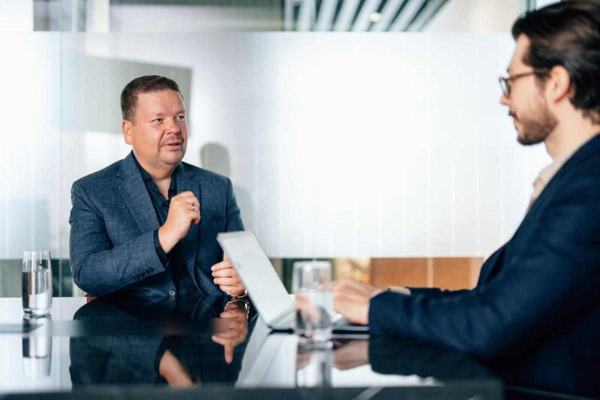 Zwei Männer besprechen die Immobilienfinanzierung in Dubai in einem Büro.