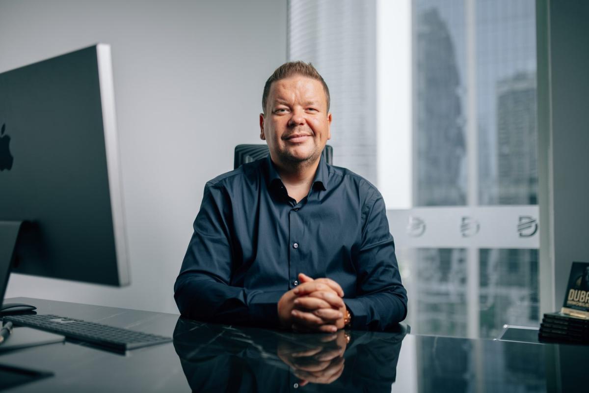 Ein Experte für Immobilienfinanzierung in Dubai posiert in einem modernen Büro.