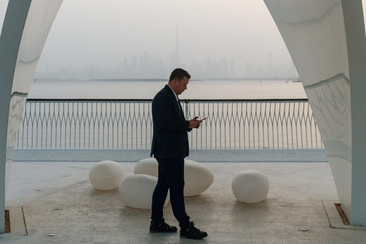 Mann am Ufer mit Blick auf die Skyline von Dubai, Mietrendite Dubai 2026.