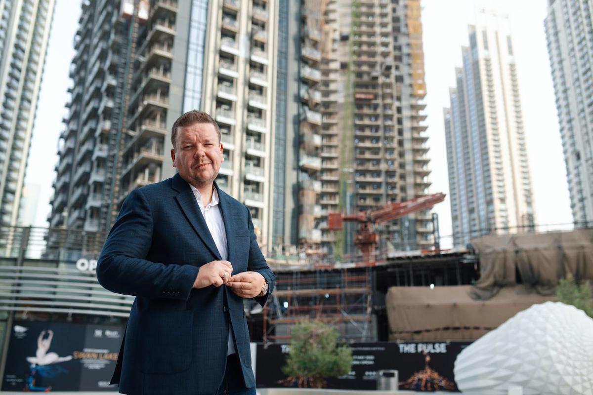 Mann vor moderner Baustelle in Dubai, RERA-Mietindex im Fokus.