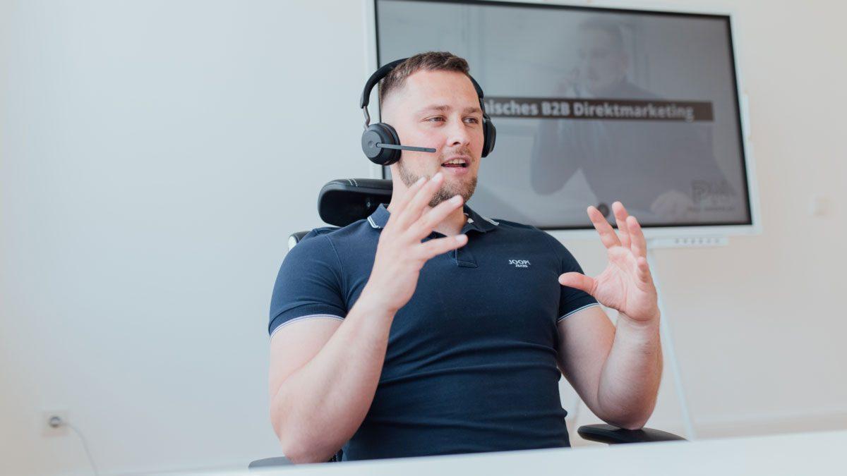 Mann in Headset gibt Tipps zur Kaltakquise am Gatekeeper.
