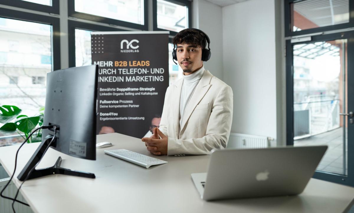 Mann im Anzug mit Headset am Schreibtisch für Lead-Nachfassung.