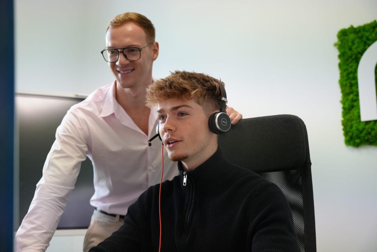 Zwei Mitarbeiter im Büro besprechen Vertriebsstrategien und Lead-Nachfassung.