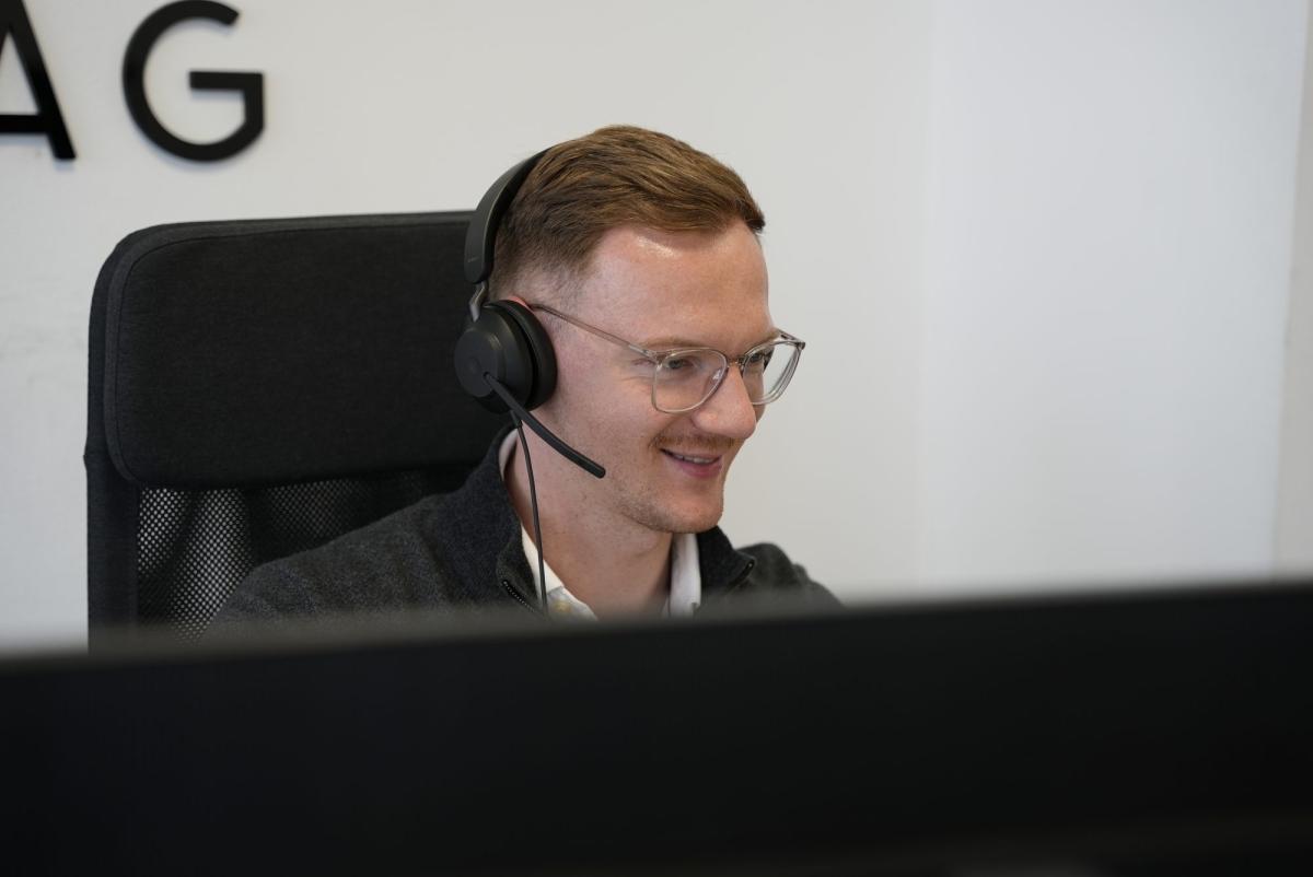 Mitarbeiter in einem Verkaufsgespräch am Telefon, der den Bedarf ernst nimmt.