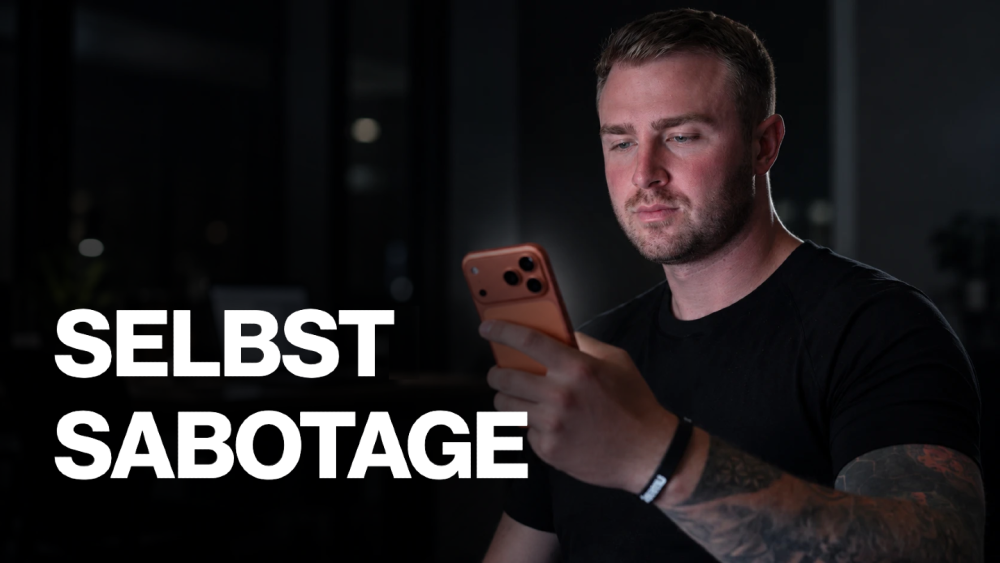 Selbstsabotage bei Selbstständigen: Ein Mann schaut auf sein Smartphone in einem dunklen Raum.
