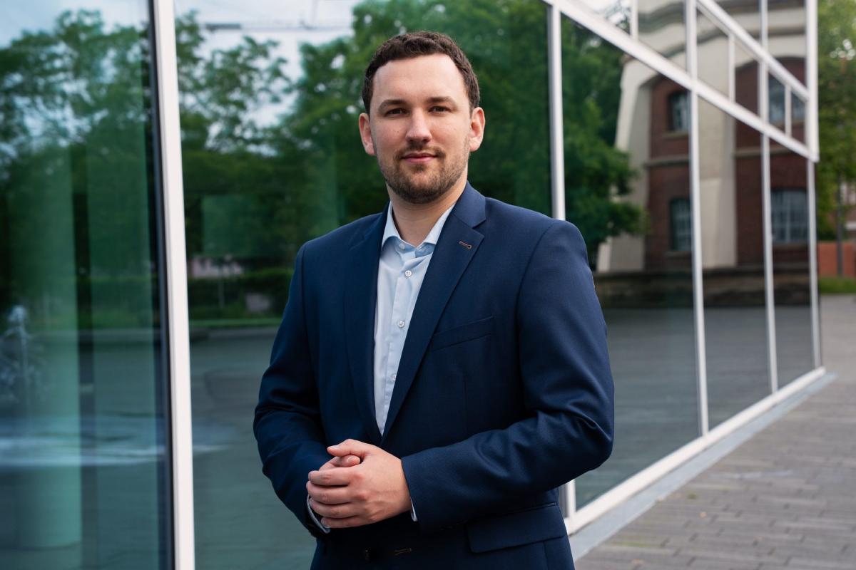 Ein Mann im dunklen Anzug steht vor einer Glasfassade; passend zum Thema IT-Sicherheit im Unternehmen.